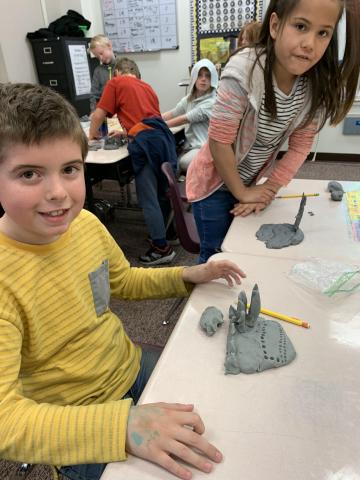2nd graders showing off their clay models
