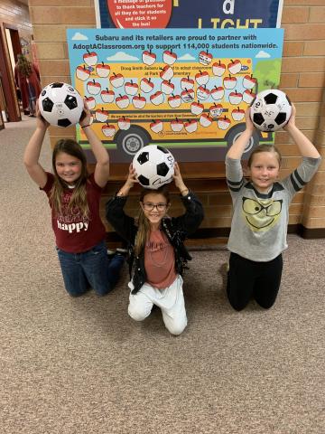 Showing off the new soccer balls. 