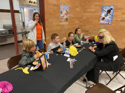 Mrs. Walker talking with students at the birthday lunch table for the birthdays in September 