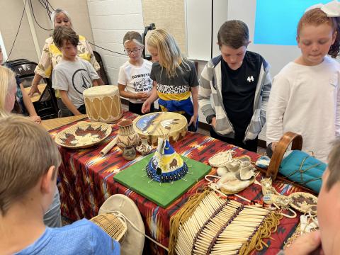 Fourth graders looking at authentic Native American items