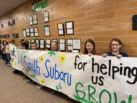 Students celebrating Doug Smith Subaru with signs of thanks!
