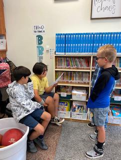 4th graders reading in groups to second grades 