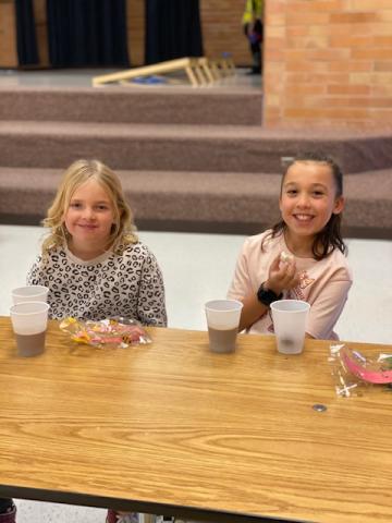 3rd grade girls enjoying chocolate milk and donut holes
