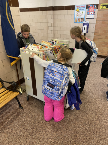 Kids picking from the Free Book Friday Cart
