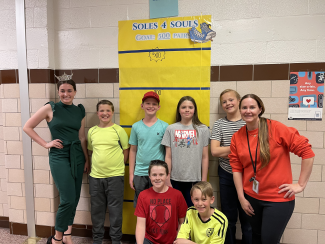 Ms. Salem, Mrs. Jindra, and Student Leaders in front of our shoe goal tracker