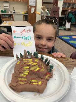 2nd graders showing off their clay models
